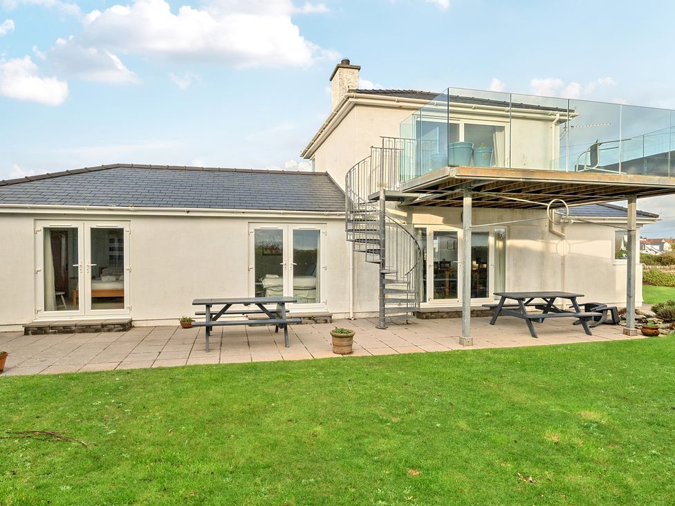 A building with a deck and stairs at Curragho in Trearddur Bay