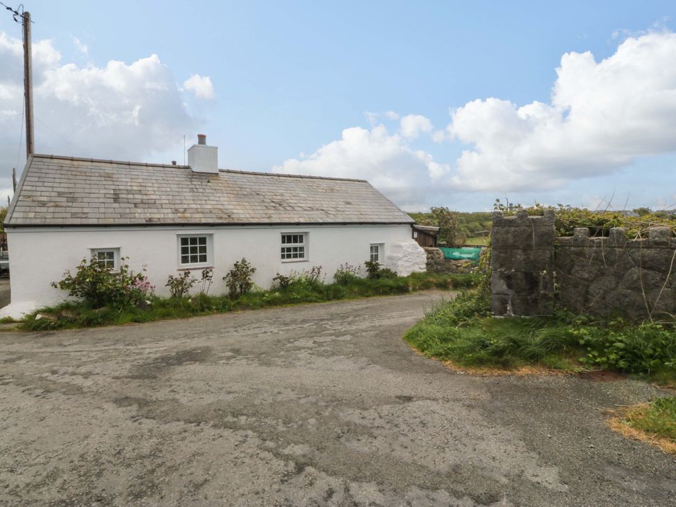 A house with windows and door near a road at Farm Cottage in Cemaes Bay