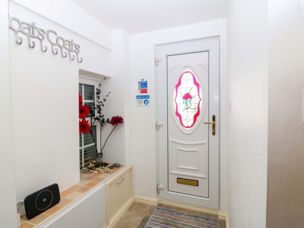 An entrance with a door and coat hooks at Farm Cottage in Cemaes Bay
