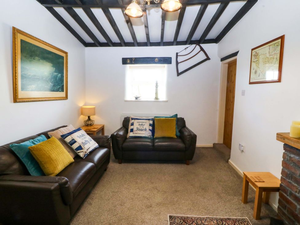 A living room with sofas and a lamp at Farm Cottage in Cemaes Bay