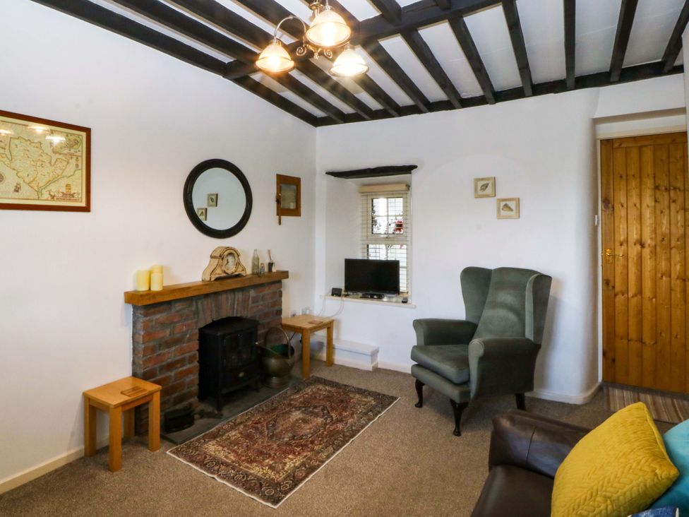 A living room with a fireplace and sofa at Farm Cottage in Cemaes Bay