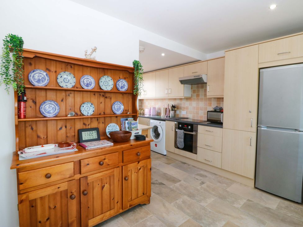A kitchen with a wooden cupboard and appliances at Farm Cottage in Cemaes Bay