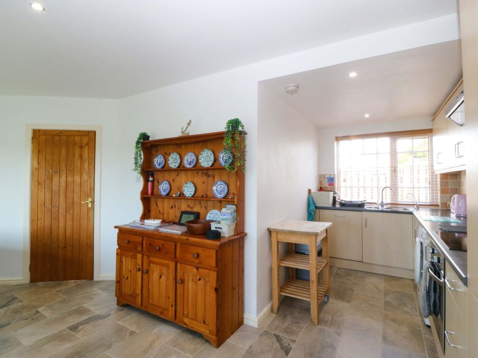 A kitchen with wooden cupboard and stove at Farm Cottage Cemaes Bay