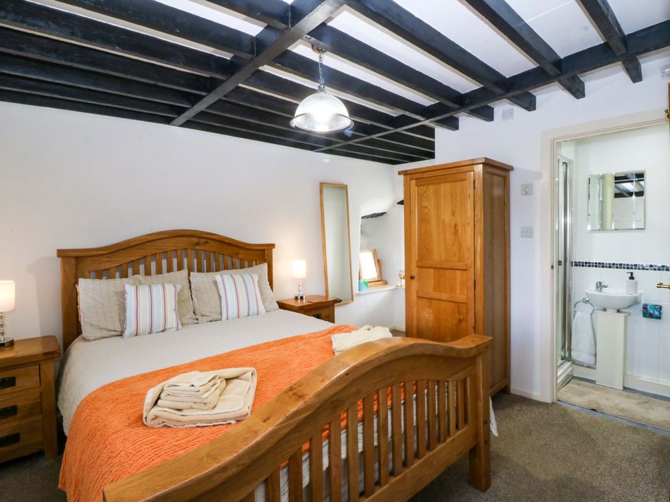 A bedroom with a bed and wardrobe at Farm Cottage in Cemaes Bay