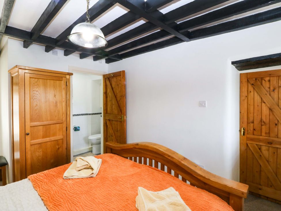 A bedroom with a bed and wardrobe at Farm Cottage in Cemaes Bay