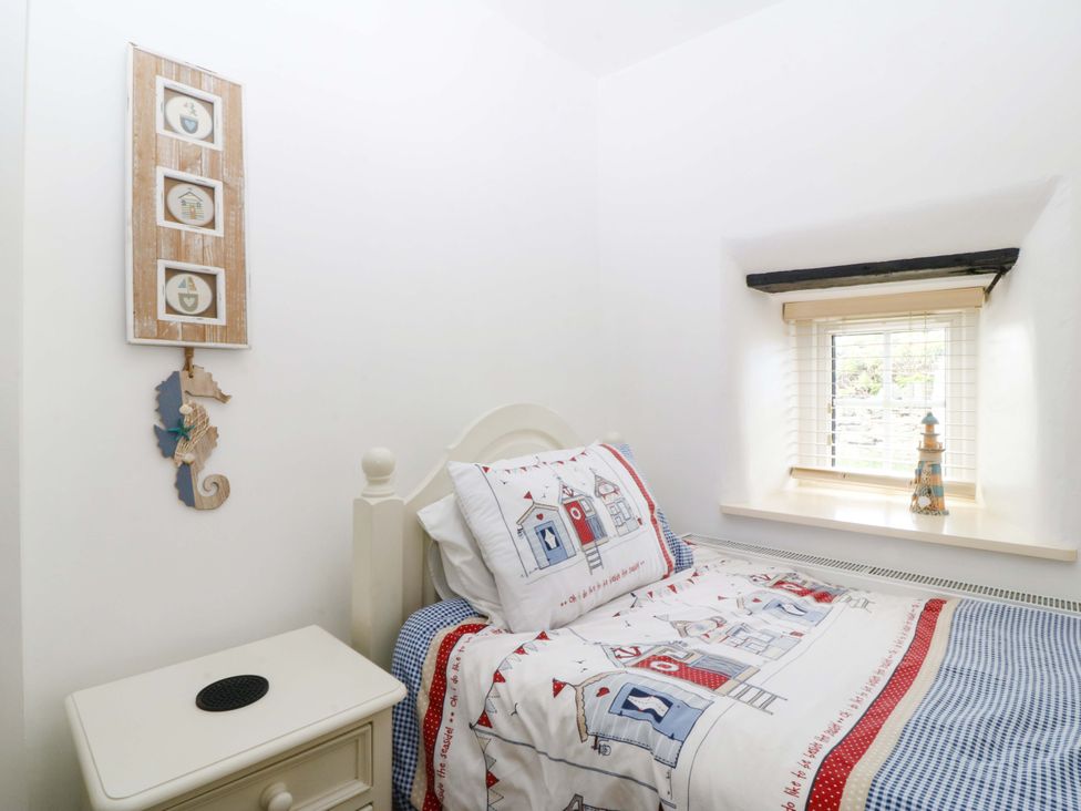 A bedroom with a bed and a window at Farm Cottage in Cemaes Bay