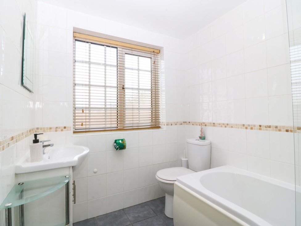 A bathroom with a sink bathtub and toilet at Farm Cottage in Cemaes Bay