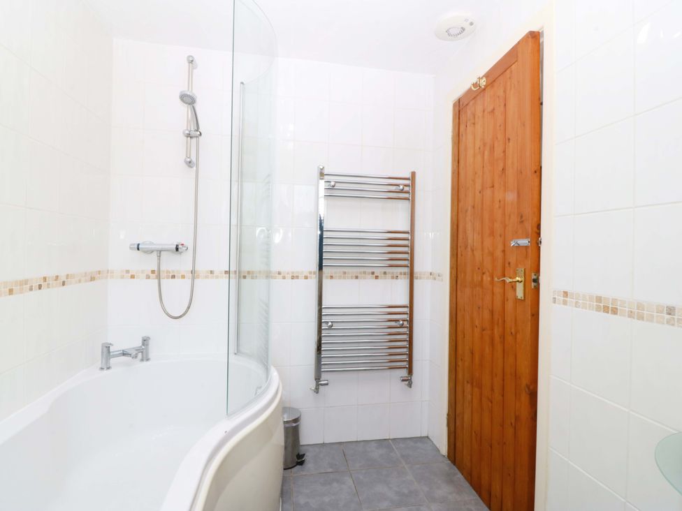 A bathroom with a bathtub and shower at Farm Cottage in Cemaes Bay