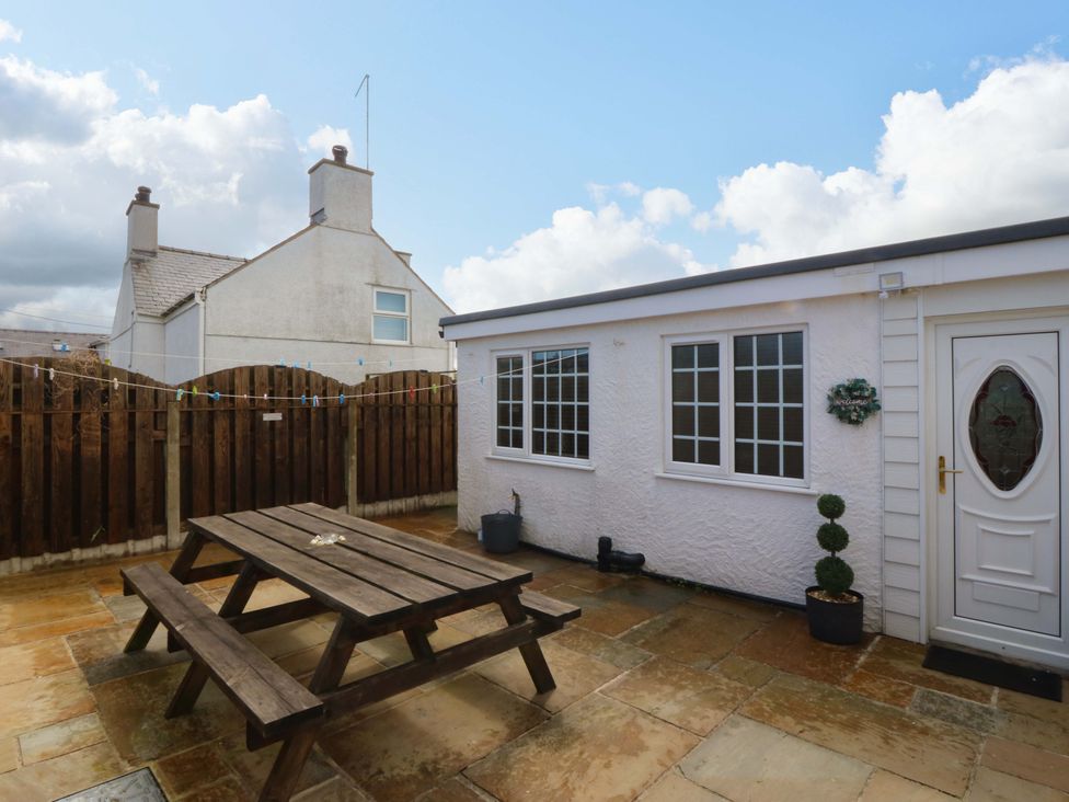 An outdoor area with a table and benches at Farm Cottage in Cemaes Bay