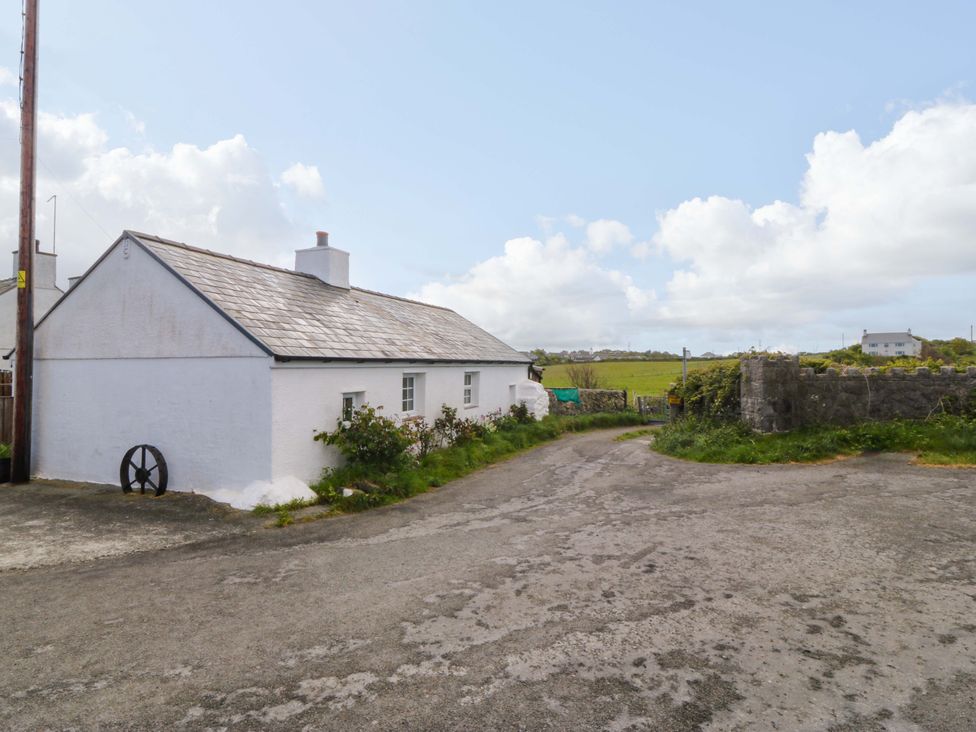 A house with a road and grass area at Farm Cottage in Cemaes Bay