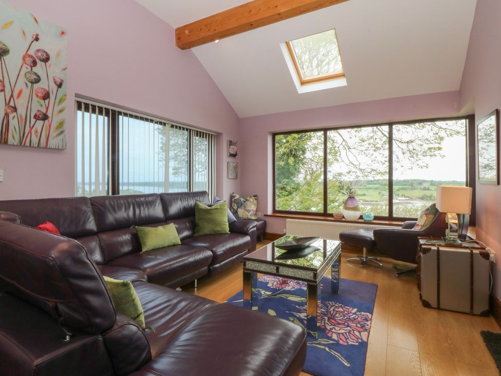 A living room with a sofa and coffee table at Gwylan Uchaf Y Felinheli