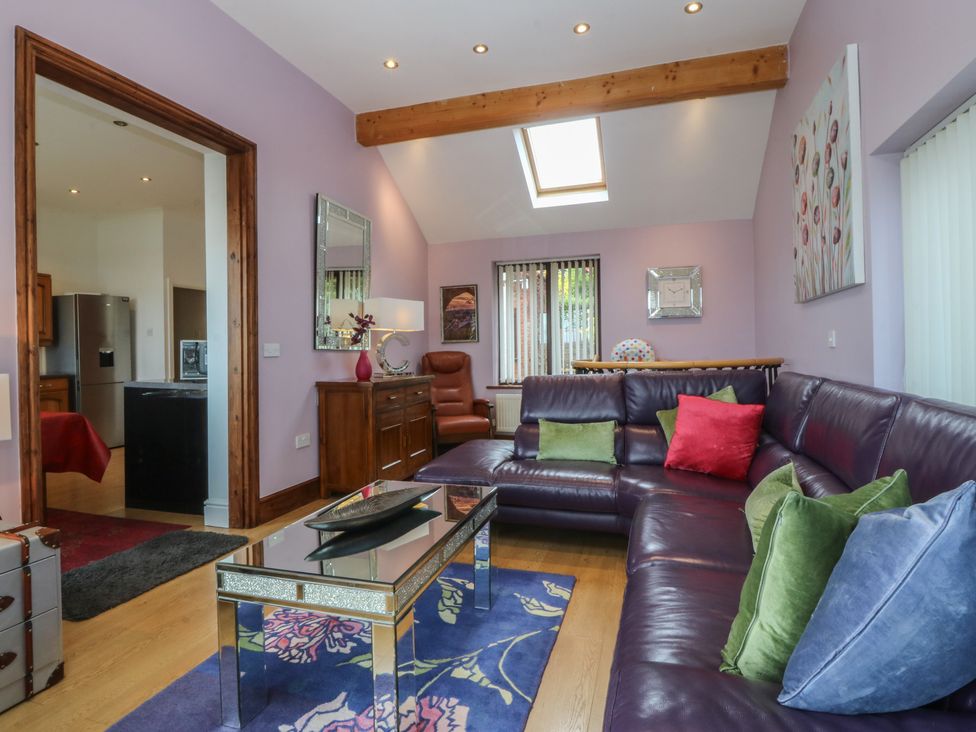 A living room with a sofa and coffee table at Gwylan Uchaf in Y Felinheli