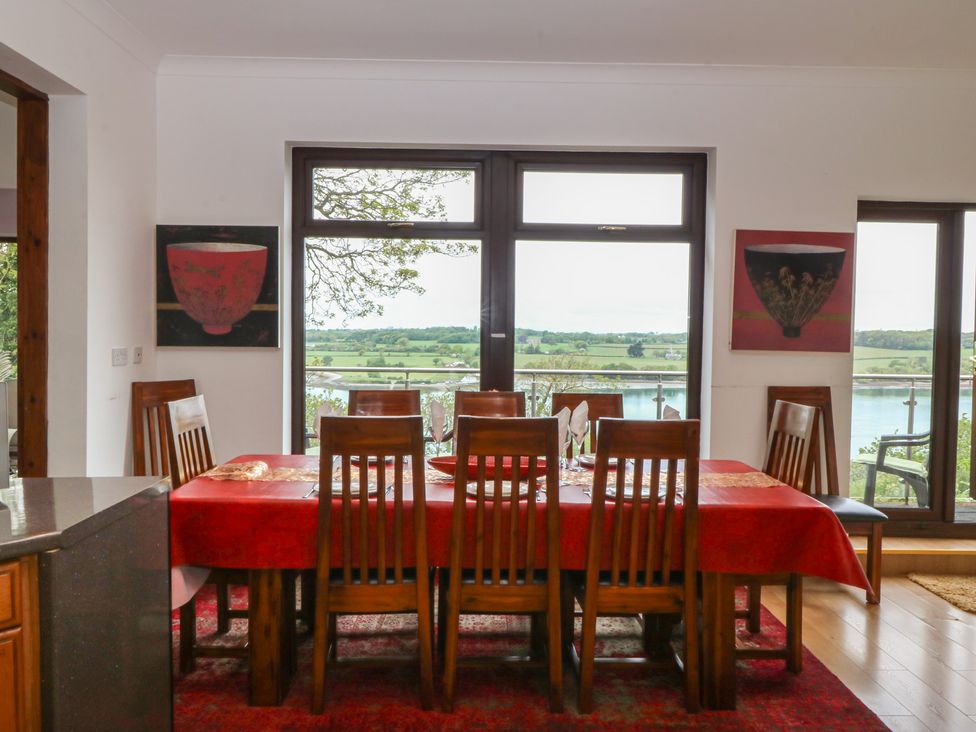 A dining room with a large table and chairs at Gwylan Uchaf Y Felinheli