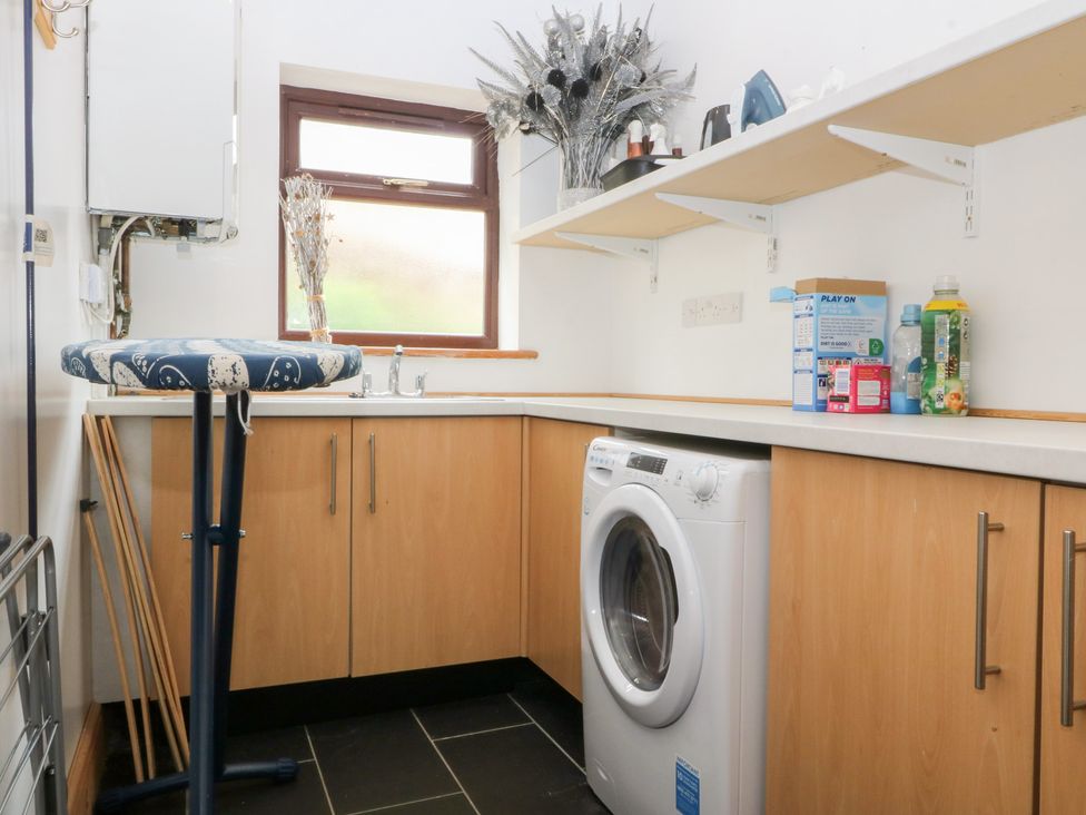 A laundry room with a washing machine and sink at Gwylan Uchaf Y Felinheli