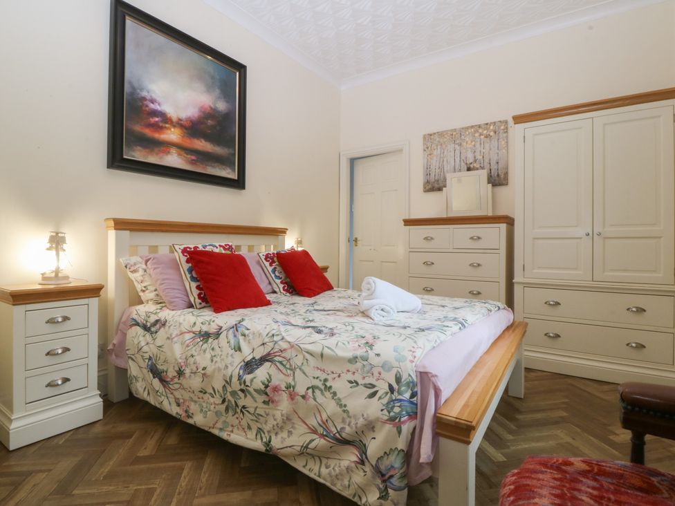 A bedroom with a bed and furniture at Gwylan Uchaf Y Felinheli