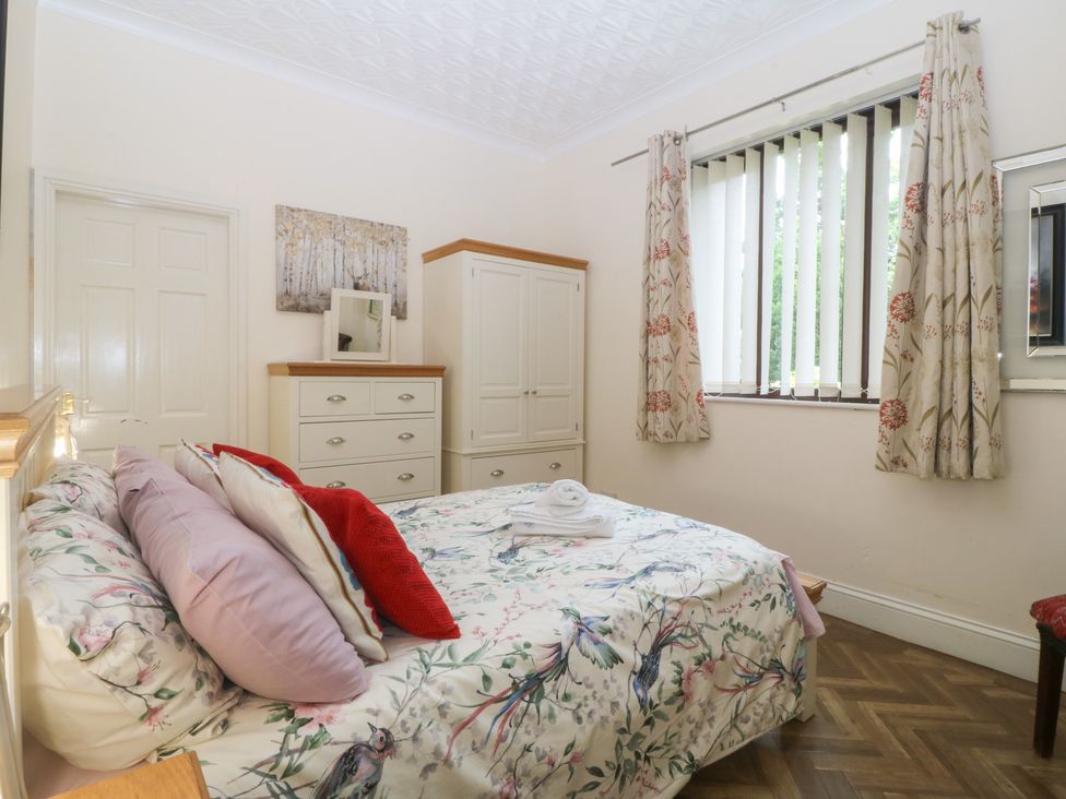 A bedroom with a bed and drawers at Gwylan Uchaf in Y Felinheli