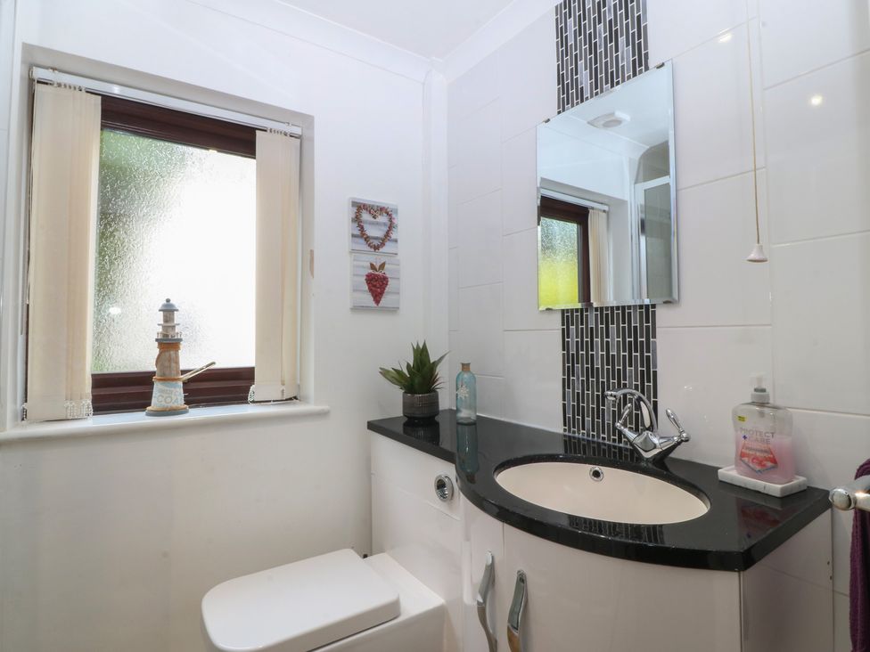 A bathroom with a sink and toilet at Gwylan Uchaf Y Felinheli