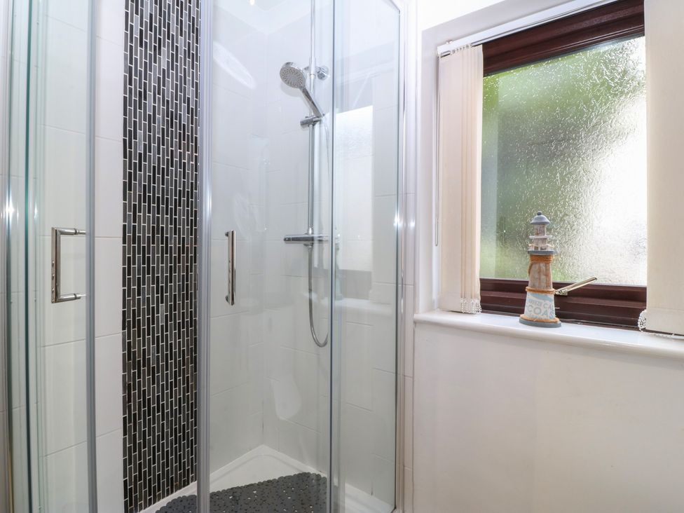 A bathroom with a shower and a decorative object at Gwylan Uchaf in Y Felinheli