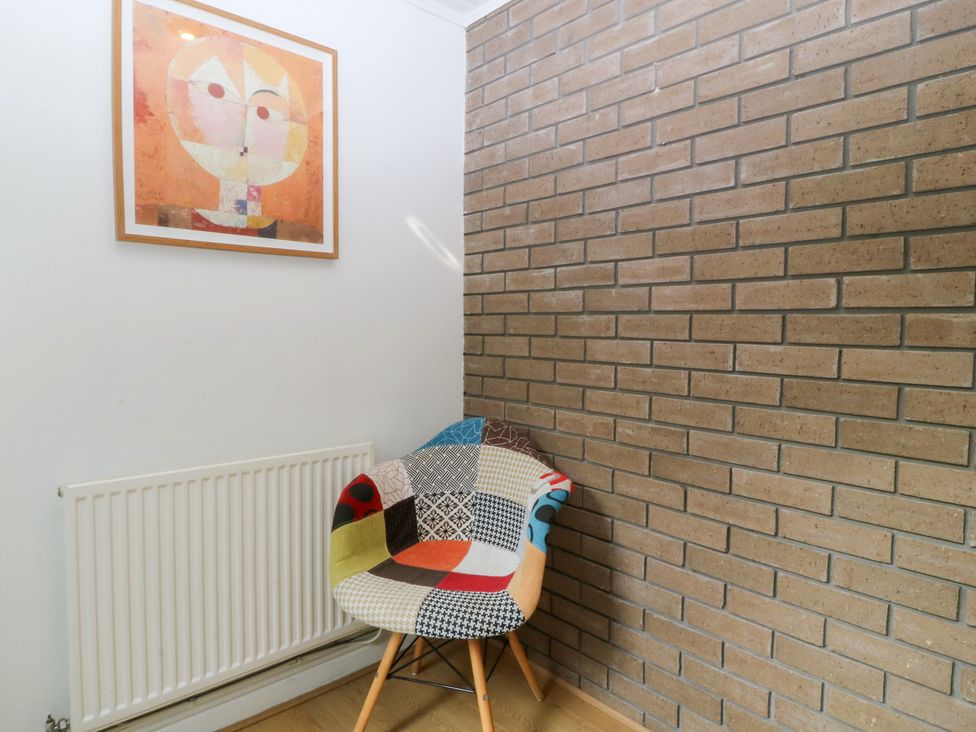 A corner with a patterned chair, radiator, and artwork at Gwylan Uchaf in Y Felinheli