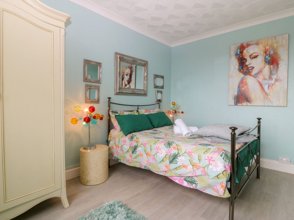 A bedroom with a bed and wardrobe at Gwylan Uchaf in Y Felinheli