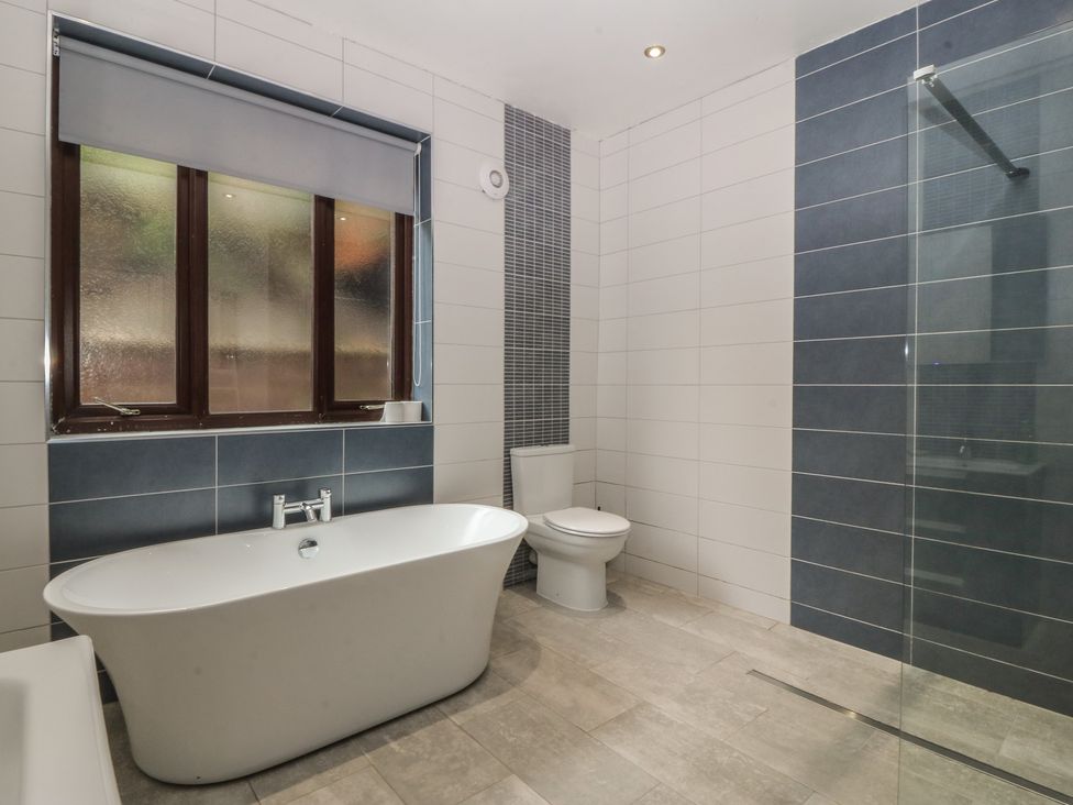A bathroom with a bathtub and shower at Gwylan Uchaf in Y Felinheli