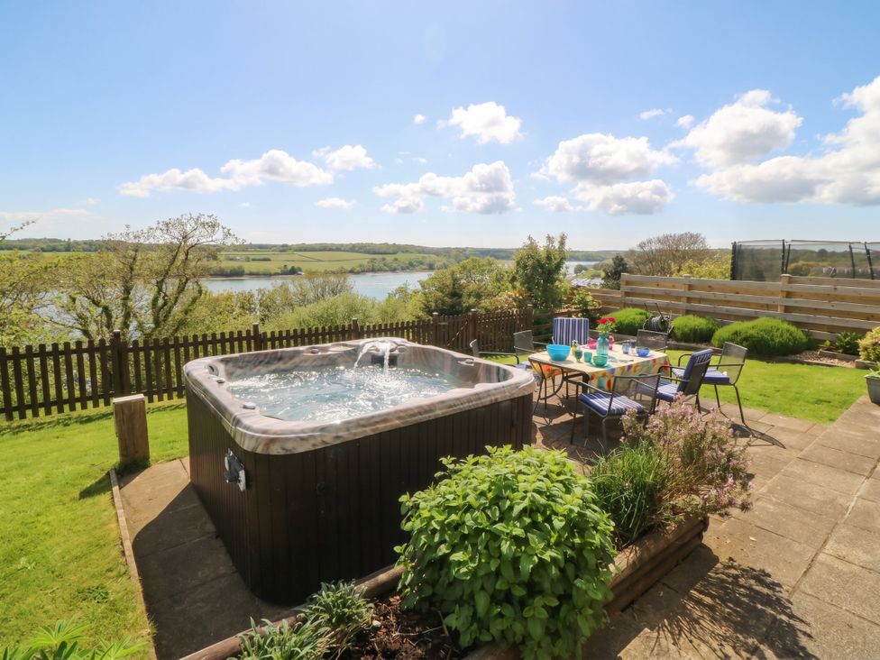 A garden with a hot tub and seating area at Gwylan Uchaf in Y Felinheli