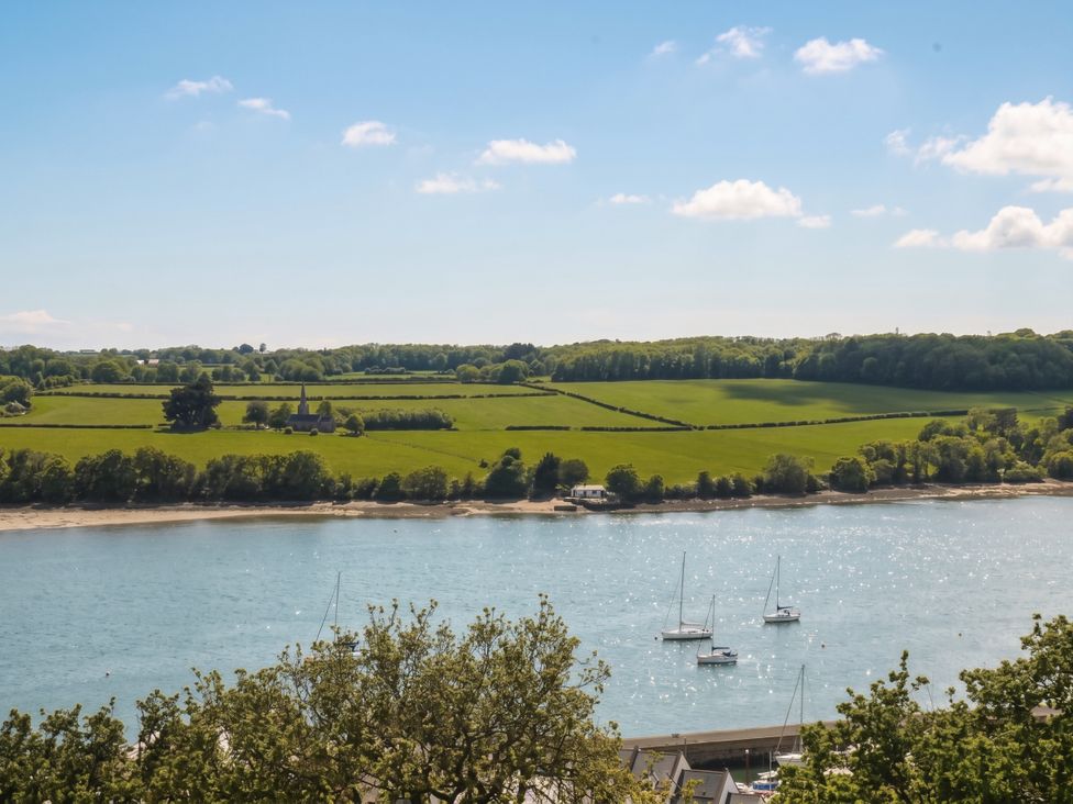 A view of a river with boats and green fields at Gwylan Uchaf Y Felinheli