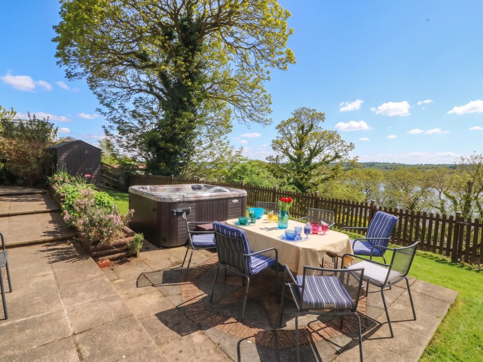 A garden with a hot tub and seating area at Gwylan Uchaf Y Felinheli