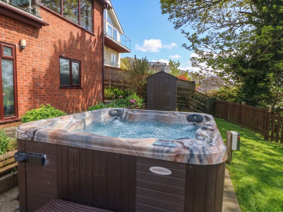 A garden with a hot tub and a shed at Gwylan Uchaf Y Felinheli