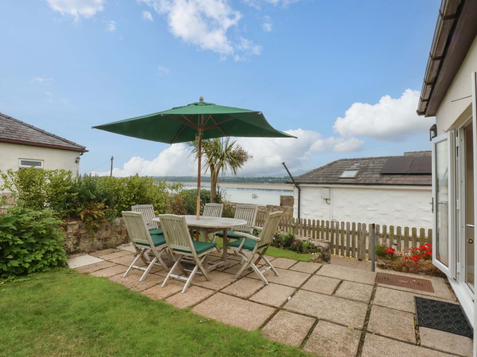 A garden with a table and chairs at Menai Cottage in Brynsiencyn