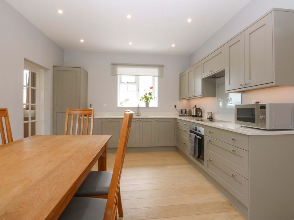 A kitchen with a table and chairs at Menai Cottage in Brynsiencyn
