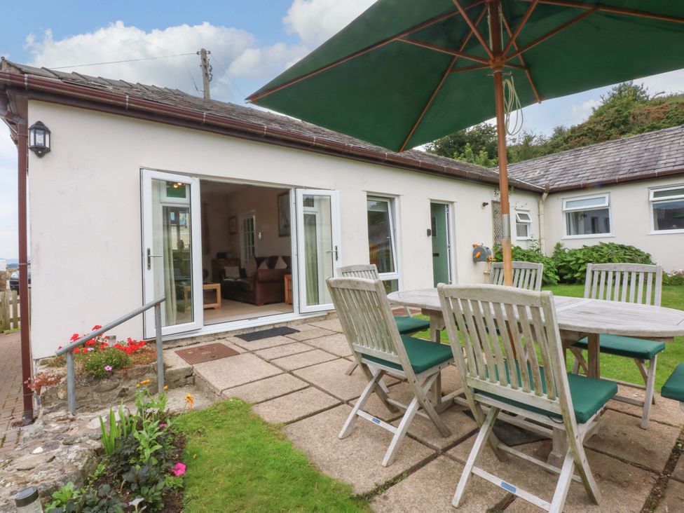 An outdoor dining area with a table and chairs at Menai Cottage in Brynsiencyn