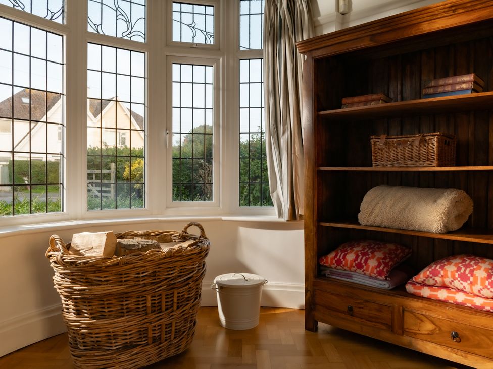 A sitting room with a wooden shelf and a basket at Summerfield in Deganwy