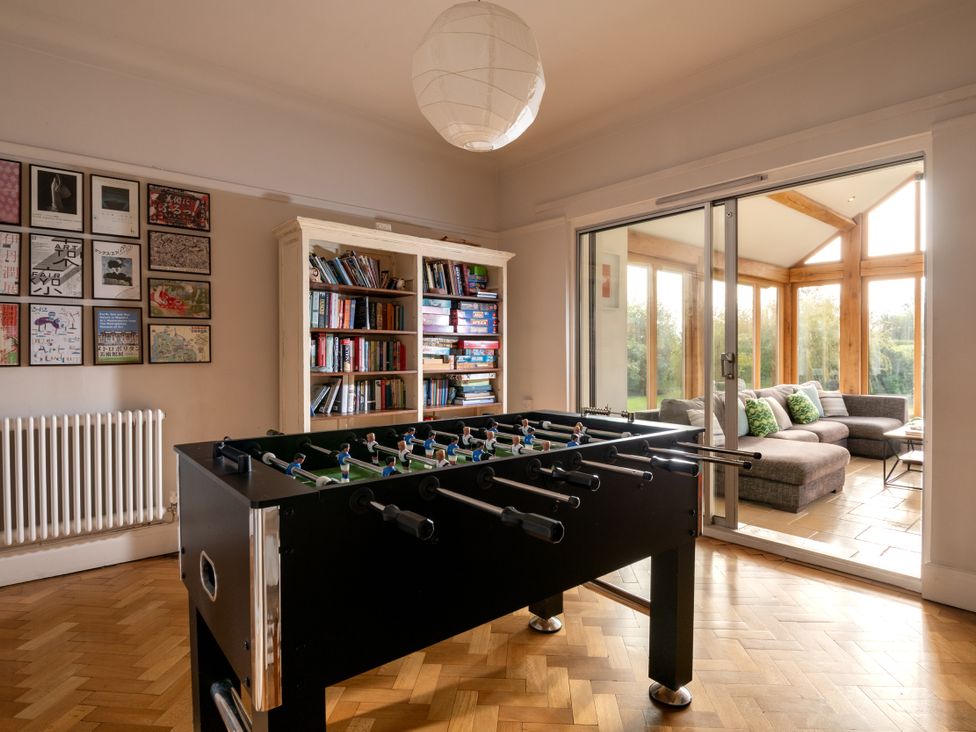 A living room with a foosball table and sliding door at Summerfield in Deganwy
