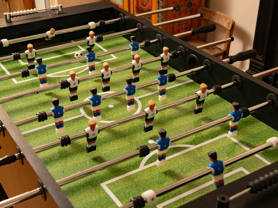 A foosball table with players and a soccer ball at Summerfield in Deganwy