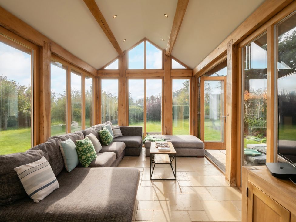 A conservatory with seating and a coffee table at Summerfield in Deganwy