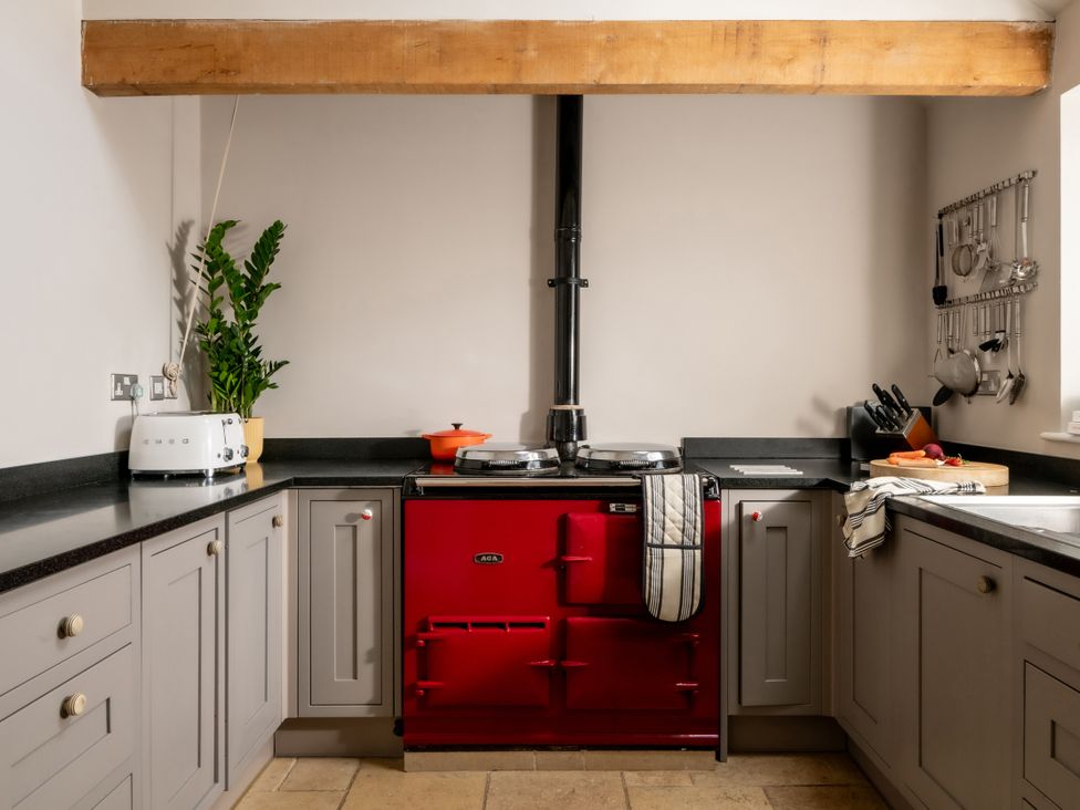 A kitchen with a red stove and countertop at Summerfield in Deganwy
