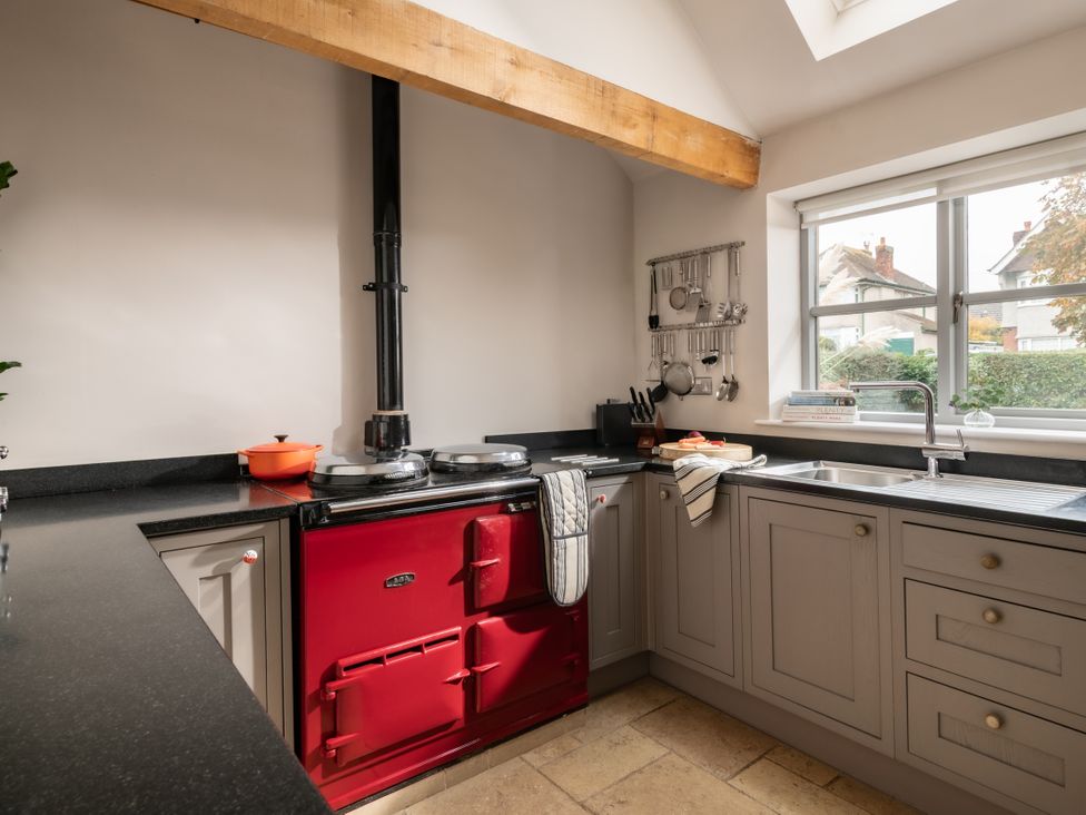 A kitchen with a red oven and sink at Summerfield in Deganwy