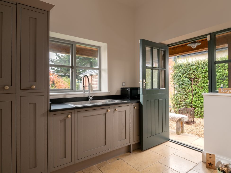A kitchen with cabinets and a sink at Summerfield in Deganwy