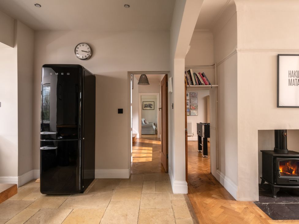 A kitchen with a fridge and clock at Summerfield in Deganwy