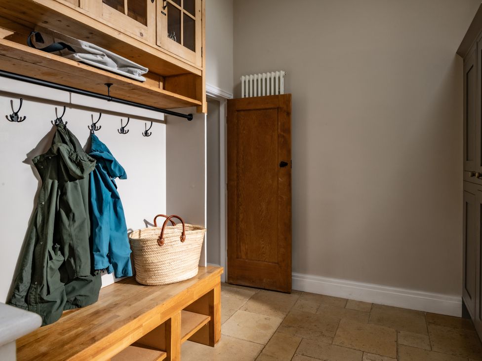 A hallway with coats on hooks and a basket at Summerfield in Deganwy