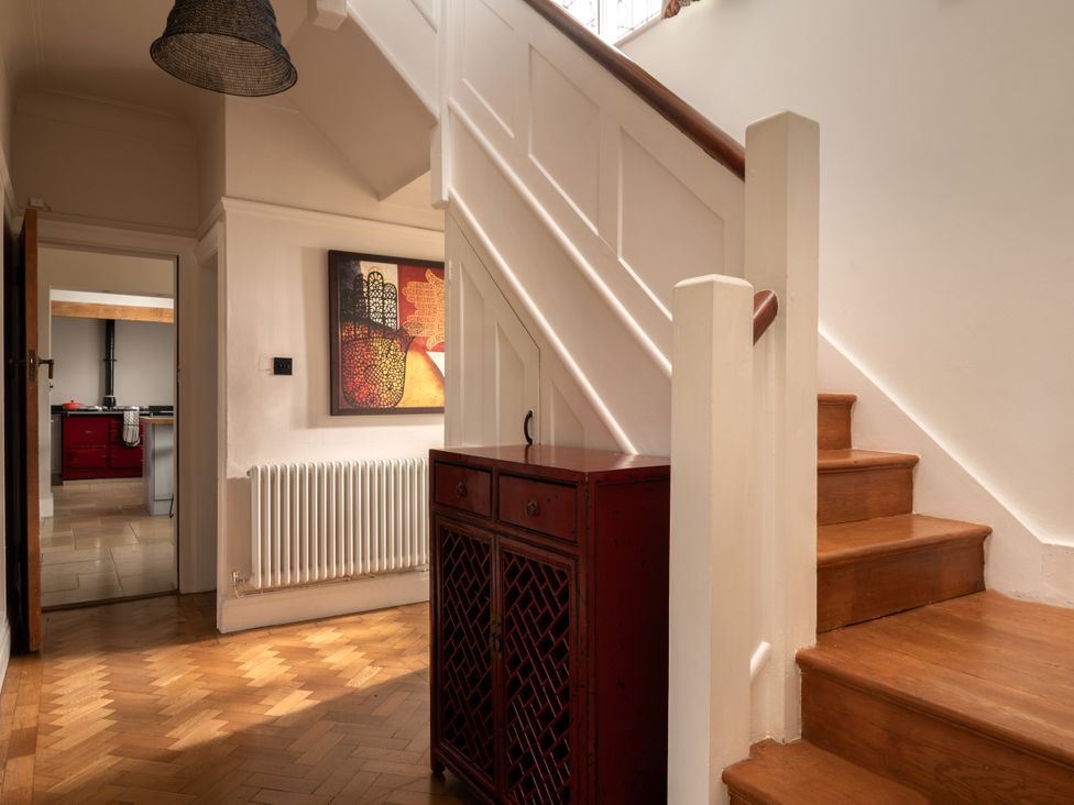 A hallway with a staircase and console table at Summerfield in Deganwy