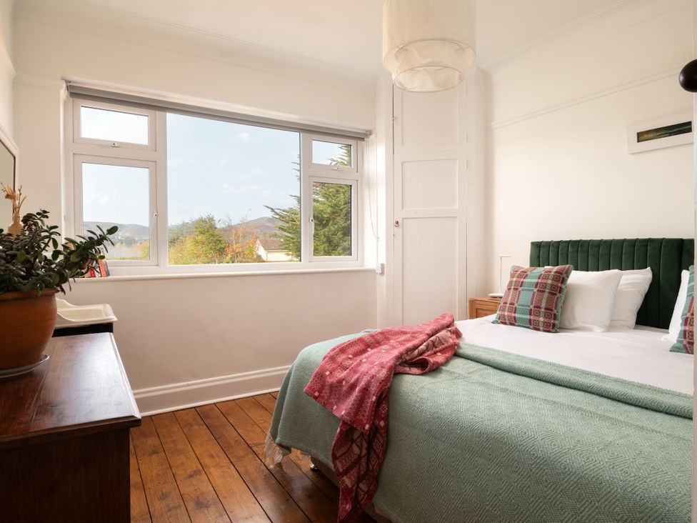 A bedroom with a bed and window at Summerfield in Deganwy