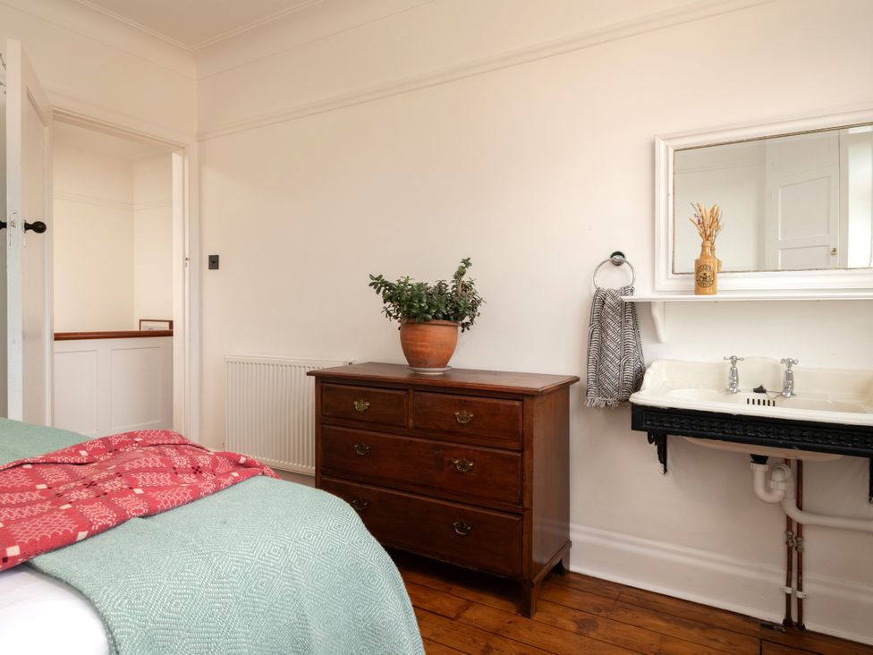 A bedroom with a dresser and sink at Summerfield in Deganwy