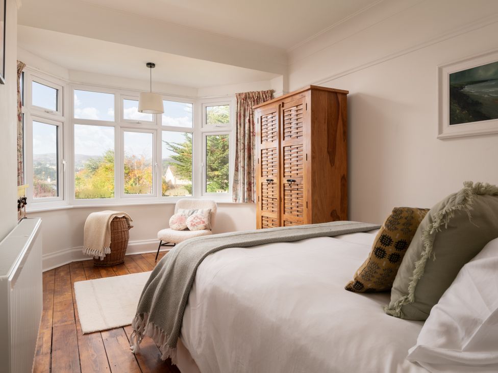 A bedroom with a window, bed, and wardrobe at Summerfield in Deganwy
