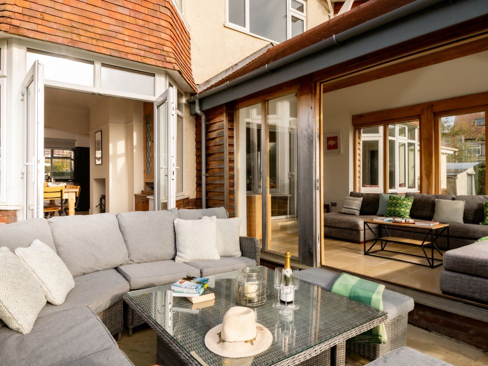 A conservatory with a sofa and coffee table at Summerfield in Deganwy