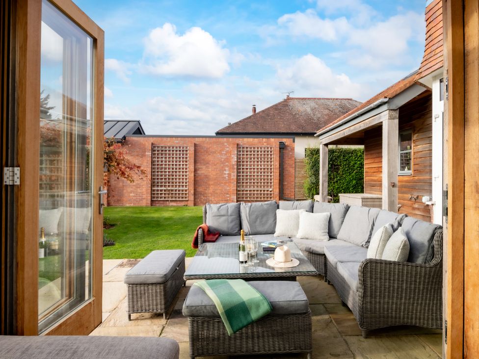 An outdoor patio with a sofa and coffee table at Summerfield in Deganwy