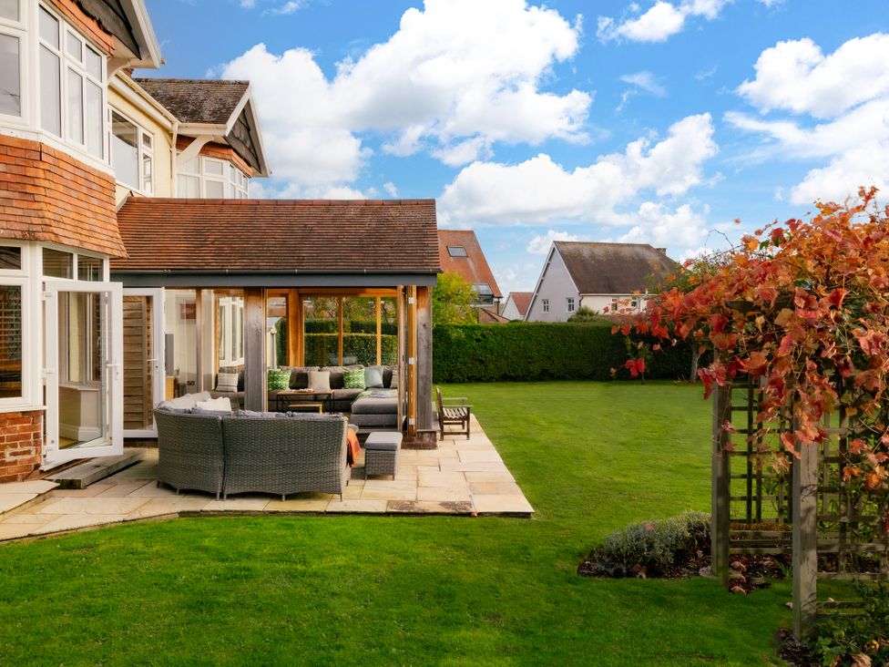 A garden with a patio and seating area at Summerfield in Deganwy