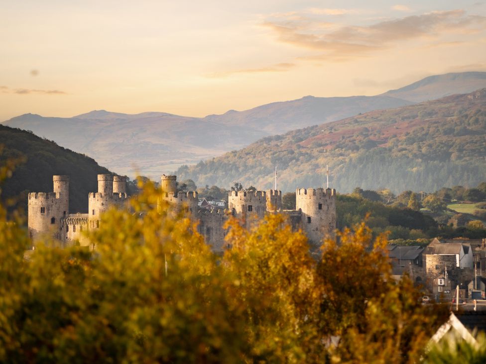 A castle with mountains in the background at Summerfield in Deganwy