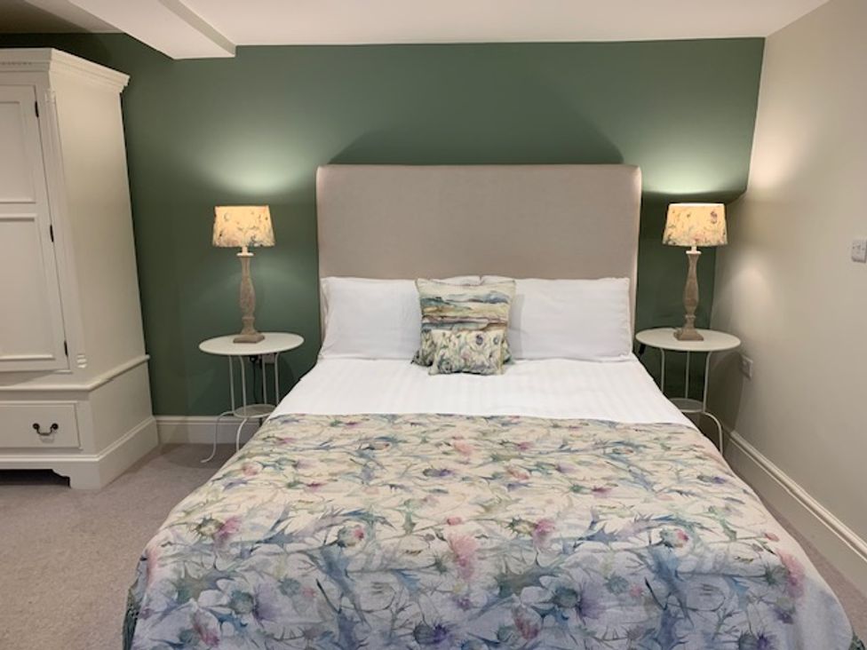 A bedroom with a bed and bedside tables at The Honey Pot in Garndolbenmaen